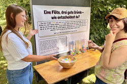 Auf dem Bild sind zwei junge Frauen. Eine erklärt der anderen etwas.