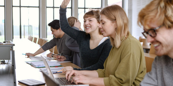 Studierende Laptops Studierende im Seminarraum sitzen in einer Tischreihe vor ihren Laptops.