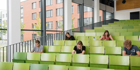 Mehrere Studierende sitzen im Hörsaal.